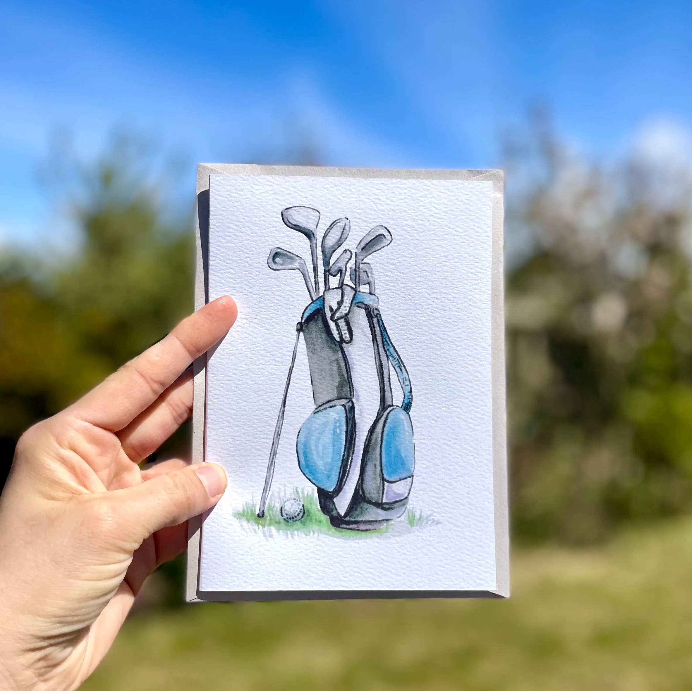 Watercolour golf clubs in a bag on an A5 greetings card