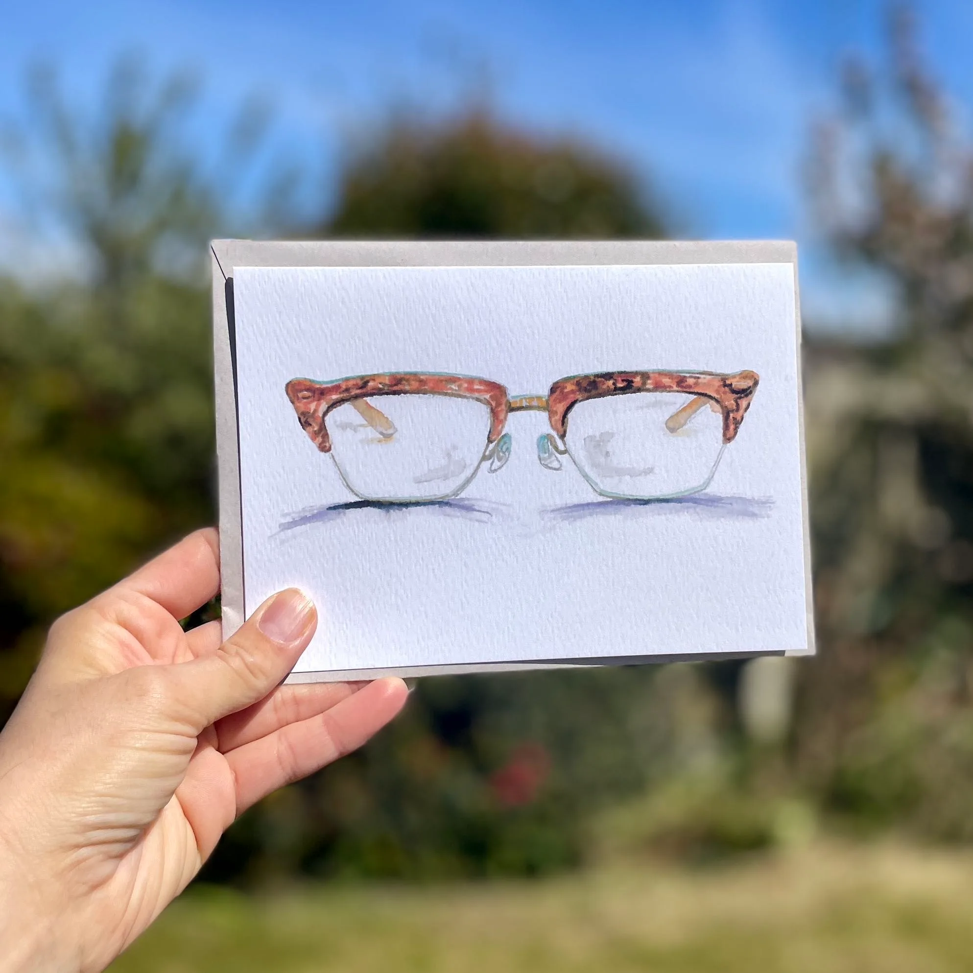 Watercolour horn rimmed glasses on an A5 greetings card